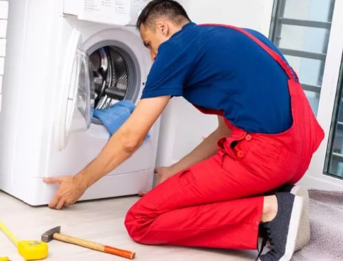 Homem alinhando os pés de uma máquina de lavar